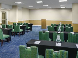 A Room With Green Chairs And Tables